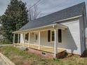 Charming home featuring a welcoming front porch with classic white pillars and black shuttered windows at 704 Mill St, Albemarle, NC 28001