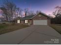 Charming brick home with a two-car garage and a well-manicured lawn, offering curb appeal and convenience at 8353 Emily Dr, Harrisburg, NC 28075