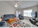 Bright living room with ample seating, a ceiling fan, and a large window for natural light at 8353 Emily Dr, Harrisburg, NC 28075