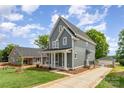 Charming two-story home features a welcoming front porch, gray siding, and a well-manicured lawn at 110 Walters St, Huntersville, NC 28078