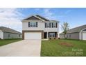 Charming two-story home featuring stone accents, a two-car garage, and a well-manicured lawn at 1113 Foxberry Ln, Maiden, NC 28650
