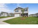Charming two-story home featuring stone accents, a two-car garage, and a green lawn at 1113 Foxberry Ln, Maiden, NC 28650