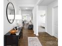 Open hallway showcasing wood floors, a stylish table with mirror, and views of the dining and bedroom spaces at 1129 Foxberry Ln, Maiden, NC 28650