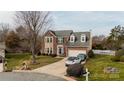 Traditional two-story brick home with dormers, two-car garage, and well-maintained landscaping at 11307 Celandine Ct, Charlotte, NC 28213