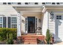Cozy front porch area with brick steps, lantern lighting, and a charming chair at 12112 Autumn Winds Ln, Pineville, NC 28134