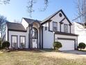 Charming two-story home with manicured lawn, arched entryway, two car garage, and gray and white trim at 13807 Queenswater Ln, Charlotte, NC 28273