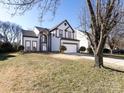 Charming two-story home with manicured lawn, arched entryway, two car garage, and gray and white trim at 13807 Queenswater Ln, Charlotte, NC 28273