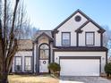 Charming two-story home with manicured lawn, arched entryway, two car garage, and gray and white trim at 13807 Queenswater Ln, Charlotte, NC 28273