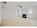 Bright living room features a fireplace, a ceiling fan, and windows to let in natural light at 140 N Arcadian Way, Mooresville, NC 28117