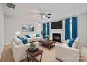 Bright living room boasts a fireplace, ceiling fan, and comfortable seating at 140 N Arcadian Way, Mooresville, NC 28117