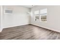 Bright and airy bedroom with three large windows and modern gray flooring at 1411 Windy Park Dr, Stanley, NC 28164