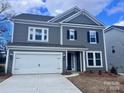 Attractive two-story home with a white garage door, complemented by dark shutters and a well-manicured lawn at 15238 Ravenall Dr, Huntersville, NC 28078
