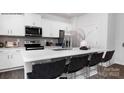 Modern kitchen features stainless steel appliances, a breakfast bar, and white cabinets at 208 Parker Claire Ln, Kings Mountain, NC 28086