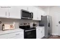Modern kitchen features stainless steel appliances, white cabinets, and ample counter space at 208 Parker Claire Ln, Kings Mountain, NC 28086