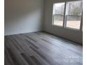 Bedroom with two large windows for plenty of natural light, and wood look vinyl flooring at 212 Sugar Hill Rd, Troutman, NC 28166