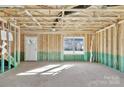 Unfinished basement with visible framing, concrete floor, and a door to the backyard at 230 Georgia Sw St # 63, Concord, NC 28025