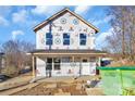 New construction home featuring a covered porch, visible framing, and builder's wrap at 230 Georgia Sw St # 63, Concord, NC 28025