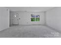 Bright, unfinished living room featuring ample natural light and a view of the surrounding neighborhood at 230 Georgia Sw St, Concord, NC 28025