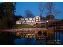 Elegant waterfront home with a private dock, beautiful lake views, and lush landscaping at 2536 Brawley School Rd, Mooresville, NC 28117