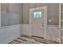 Bright entryway with wainscoting, stylish floors, and a glass-paneled front door at 415 E Richland St, Kershaw, SC 29067
