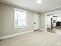 Inviting living room with large windows and carpet, seamlessly connecting to the adjacent kitchen at 5028 Wilgrove Mint Hill Rd, Mint Hill, NC 28227