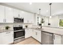 Modern kitchen featuring stainless steel appliances, granite countertops, and sleek white cabinetry at 5404 Maplewood Ln, Charlotte, NC 28227