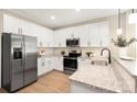 Bright kitchen featuring stainless steel appliances, granite countertops, and white cabinetry at 5404 Maplewood Ln, Charlotte, NC 28227