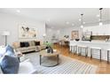 Bright open-concept living room boasts contemporary decor, hardwood floors, and a seamless flow to the kitchen at 5404 Maplewood Ln, Charlotte, NC 28227