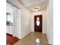 Welcoming entryway featuring tile flooring, a dark wood front door and access to kitchen at 5610 Stone Bluff Ct, Charlotte, NC 28214
