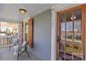 Inviting front porch with seating area, natural wood door, and decorative wood window shutters, #701 at 701 S Torrence St, Charlotte, NC 28204