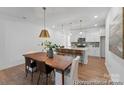 Modern dining room features stylish lighting, hardwood floors, and a view of the kitchen at 116 Shay Crossing Rd # 2P, Salisbury, NC 28144