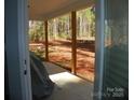 Covered outdoor patio with wood pillars and a view of the backyard and surrounding wooded area at 128 Summerlake Dr, New London, NC 28127