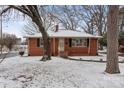 Charming red brick home with black shutters and landscaped yard covered in a light dusting of snow at 1401 Walker St, Salisbury, NC 28144