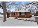 Charming red brick home with black shutters and landscaped yard covered in a fresh dusting of snow at 1401 Walker St, Salisbury, NC 28144
