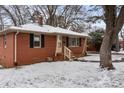 Charming red brick home with black shutters and landscaped yard covered in a fresh coating of snow at 1401 Walker St, Salisbury, NC 28144