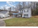 Well-maintained two-story home with a covered parking area and green lawn at 2444 Fabyan Ln, Charlotte, NC 28262