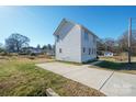 Exterior view of the backyard with a back entrance, small porch and concrete parking area at 418 N Pear St, Gastonia, NC 28054