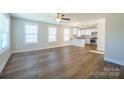 Open-concept living room showcasing wood-look flooring, large windows, and seamless flow into the kitchen at 418 N Pear St, Gastonia, NC 28054