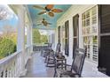 Relaxing front porch with rocking chairs, ceiling fans, and a view of the outdoors at 9128 Summer Club Rd, Charlotte, NC 28277