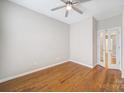 Bright bedroom featuring a ceiling fan, hardwood floors, and an adjacent room at 1001 Mesa Verde Dr, Fort Mill, SC 29707