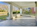 Spacious covered porch with a painted brick floor, and white railing and columns at 137 Lancaster St, Chester, SC 29706