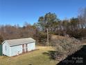 Outdoor storage shed with a blue exterior, double doors, and a roof at 2084 W Memorial Hwy Rd, Union Grove, NC 28689