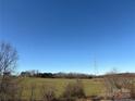Scenic rural view with an open field, power lines, trees, and clear blue sky at 2084 W Memorial Hwy Rd, Union Grove, NC 28689
