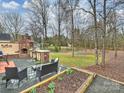 Spacious backyard with outdoor kitchen, seating area, wooded views, and decorative brick grill area at 2405 Ivy Run Dr, Indian Trail, NC 28079