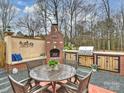 Outdoor dining area features a table with seating, a fireplace, and an outdoor kitchen at 2405 Ivy Run Dr, Indian Trail, NC 28079