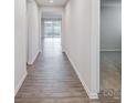 Inviting hallway with modern wood floors leads to a bright living space with sliding glass doors at 2656 Tillman St, Monroe, NC 28112