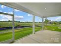 Covered patio overlooking a manicured lawn and a lush field under a clear, blue sky at 2656 Tillman St, Monroe, NC 28112