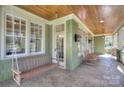 Relaxing covered porch with a swing, rocking chairs, and a wood plank ceiling at 324 Wendover Hill Ct, Charlotte, NC 28211