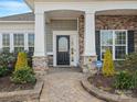 Inviting front porch with stone columns and manicured landscaping, leading to a beautiful front door at 4030 Ambleside Dr, Fort Mill, SC 29707