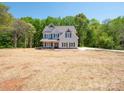 Beautifully crafted two-story home with a charming exterior, set against a backdrop of lush green trees at 5311 Meadowland Pkwy, Monroe, NC 28112